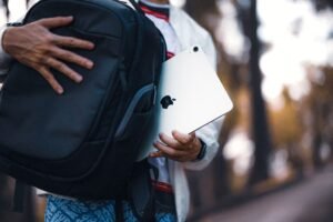 Traveler with a black backpack and tablet on an outdoor path