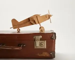 Vintage suitcase with a wooden plane, symbolizing Which Country is Best for Senior Citizens to Travel