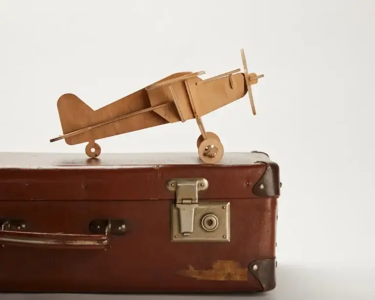 Vintage suitcase with a wooden plane, symbolizing Which Country is Best for Senior Citizens to Travel