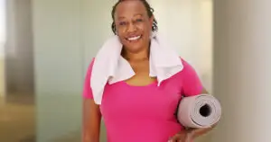 An elderly African American woman poses for a portrait after her workout, Health tips for senior travelers