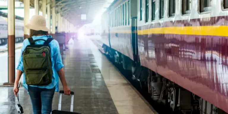 Solo female traveler with backpack at train station, focusing to Stay Safe When Traveling Alone.