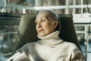woman over 60 sitting quietly with a book — healing after 60 through slow living