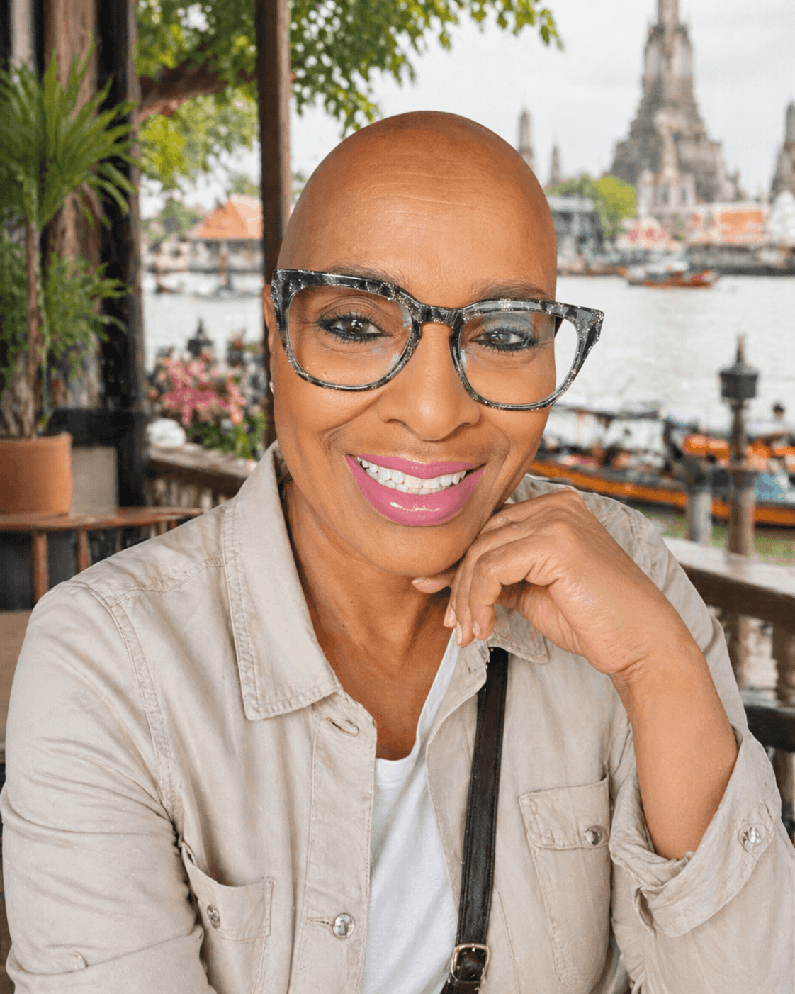 Mary Johnson of Traveling Savvy Seniors smiling at a riverside café during slow travel abroad