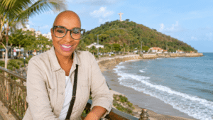 Smiling woman overlooking the Vung Tau coastline with beach and hillside statue in the background